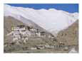A Tibetan temple is built atop a hill with the Himalaya Mountains as a backdrop