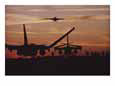 Silhouetted planes on an aircraft carrier at twilight