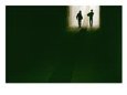 Silhouettes of two cowboys walking out of a tunnel.