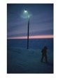 A Person Walks Down a Snow-Covered Street at Twilight