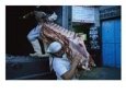 Butchers unload sides of beef from a refrigerated truck