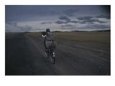 A Musician, Horn Strapped to His Back, Bicycles in a Remote Landscape