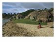 Fijian Woman Sitting on the Beach near her Village