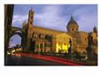 Twilight View of Towered Building and Statues along a Street