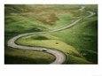 Car Travelling Down Snaking Road Through Grazing Land of the Peak District, United Kingdom