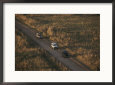 Aerial View of Land ROVers Travelling a Dirt Road in the Park