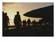 Silhouetted Military Personnel on an Aircraft Carrier at Twilight